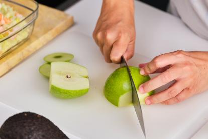 Cortar la manzana con piel, primero por la mitad y luego en cuartos