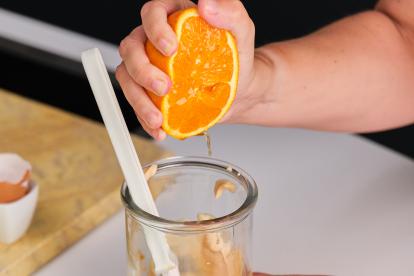 En el mismo vaso, añadir el zumo de media naranja y una cucharadita de brandy, y terminar de mezclar a mano.