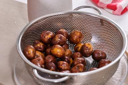 Lavar las patatas en un colador