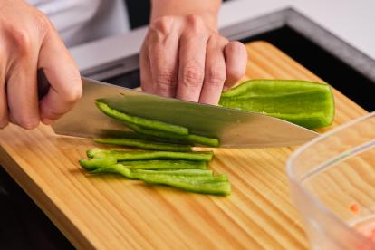 Cortar el pimiento verde con un cuchillo en trozos pequeños