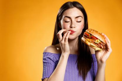 Chica comiendo hamburguesa.