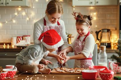 Una madre elabora con sus hijos una receta de galletas de Navidad.