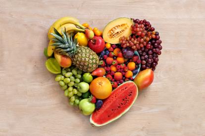 Heart symbol. Fruits diet concept. Healthy eating concept / food photography of heart made from different fruits on wooden table. Copy space. High resolution product.