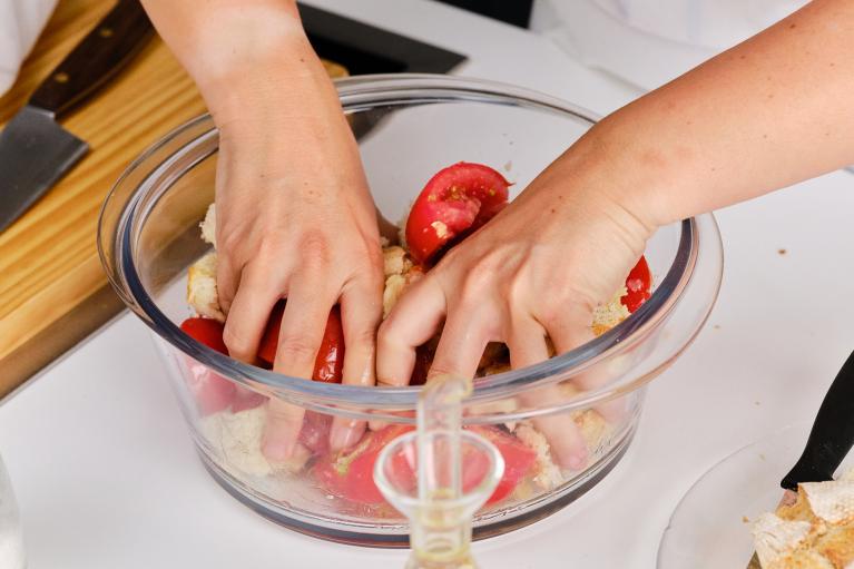 Con las manos limpias, mezclar estrujando un poco los ingredientes, para que el tomate termine mojando todo el pan