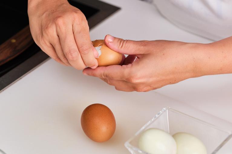 Cuando los huevos cocidos estén fríos, pelar con las manos.