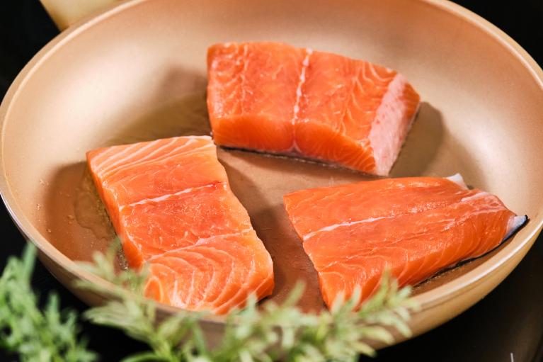 Cocinar el salmón en la sartén por el lado de la piel