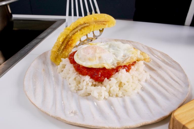 Servir el arroz con tomate frito, el huevo y el plátano